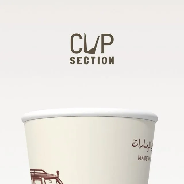 Cream paper cup with a maroon sketch of a vintage 4x4 and the line Made in UAE in Arabic and English.