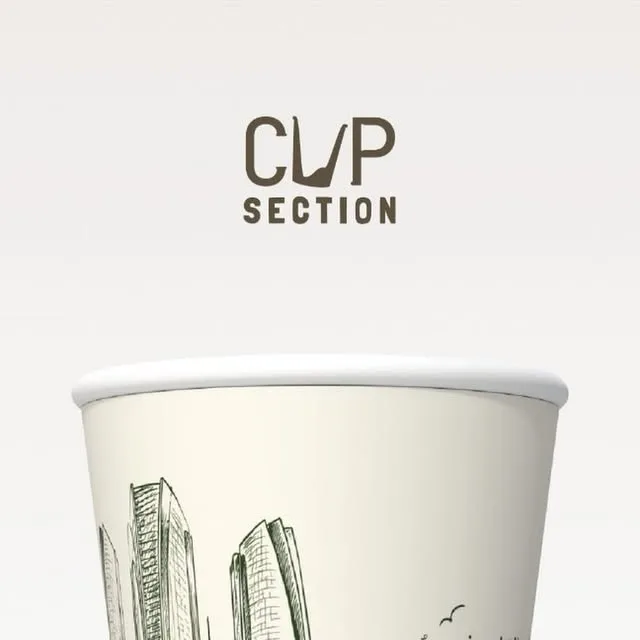 Cream paper cup with a pencil-style sketch of city towers in green ink and two small birds.